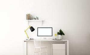 Optimale Büroeinrichtung - Arbeitsplatz mit Desktop-Computerbildschirm auf weißem Schreibtisch, mit Lampe, Stuhl und Büroschrank unter dem Tisch.