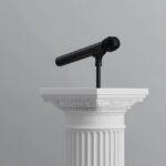 Ein schwarzes Mikrofon auf einem weißen Podium – Symbol für die Professionalität und Bedeutung des Berufs Trauerredner werden