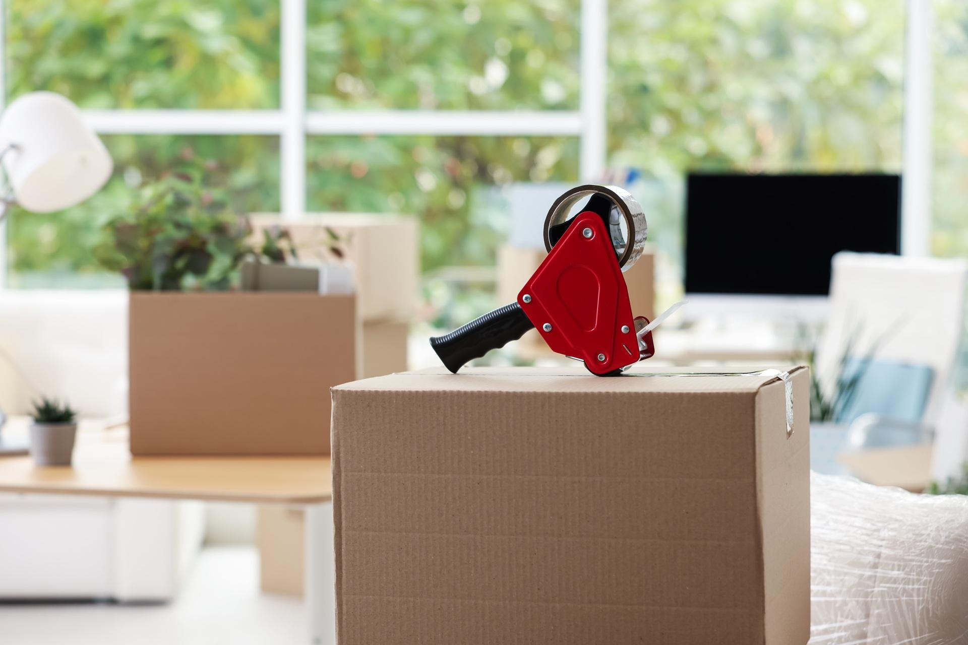 Klebegerät liegt auf Umzugskarton | Papierpolster